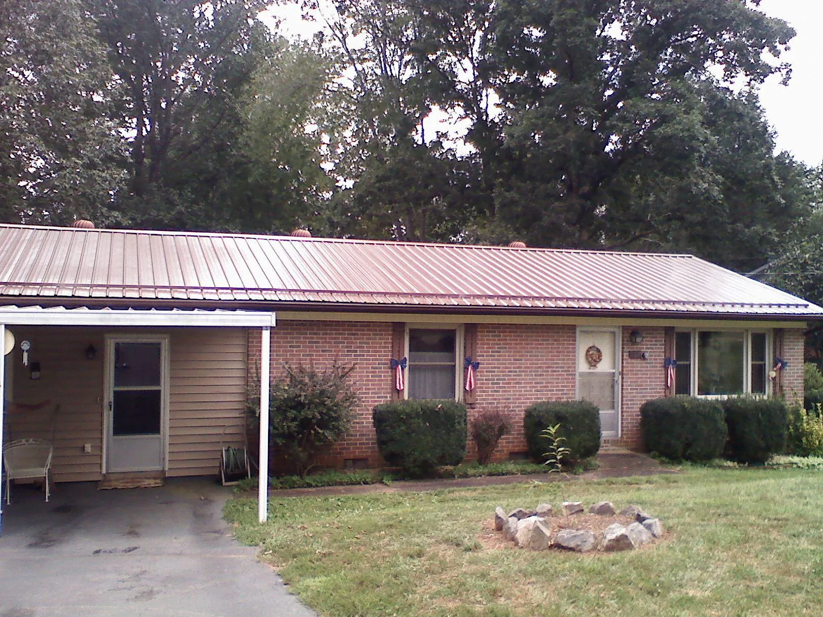 Bronze metal roof and carport on a brick ranch home — Roof Repair work by our crew in Sekiu